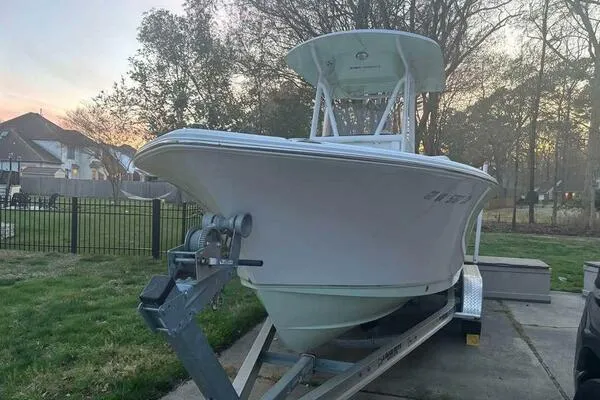 Slide: The Image of 2017 Sea Hunt Ultra 225 boat on trailer, parked in a residential driveway at sunset. - 56