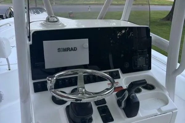 Slide: The Image of 2017 Sea Hunt Ultra 225 boat dashboard with Simrad navigation system and steering wheel. - 59