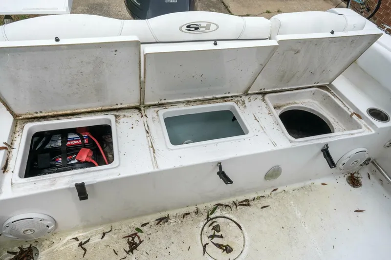 Slide: The Image of 2017 Sea Hunt Ultra 225 boat storage compartments with battery and debris. - 9