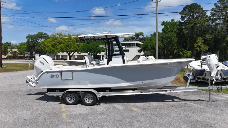 The Image of 2024 Sea Hunt Ultra 239 SE boat on a trailer, parked outdoors. - 1