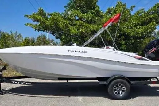 The Image of 2025 Tahoe T18 boat on trailer, parked outdoors under clear blue sky. - 0