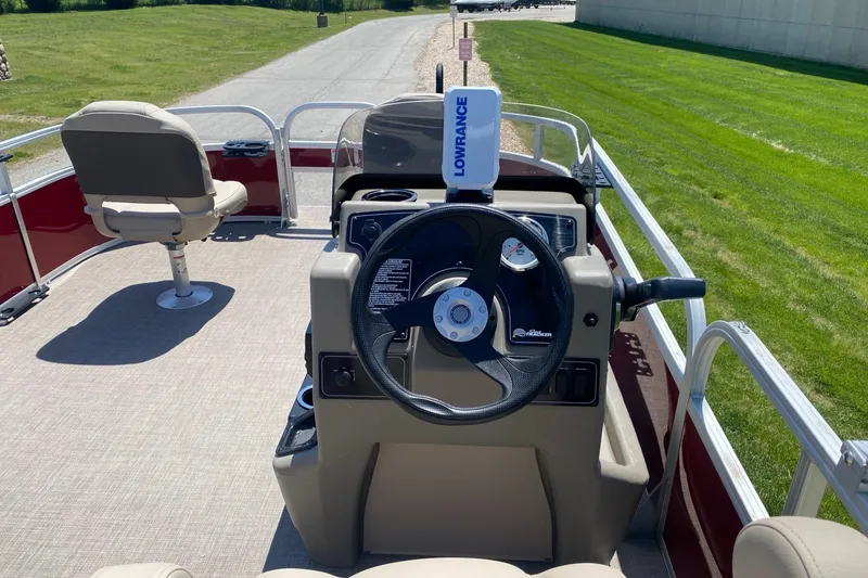Slide: The Image of 2025 Sun Tracker Bass Buggy 16 XL Select pontoon boat interior with steering console and seating. - 2