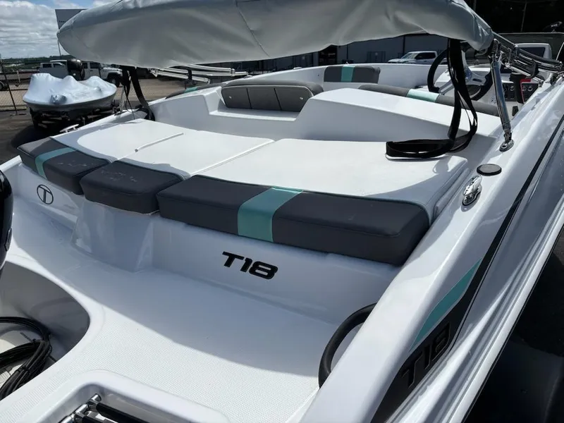 Slide: The Image of 2025 Tahoe T18 boat with cushioned seating and sleek design. - 2