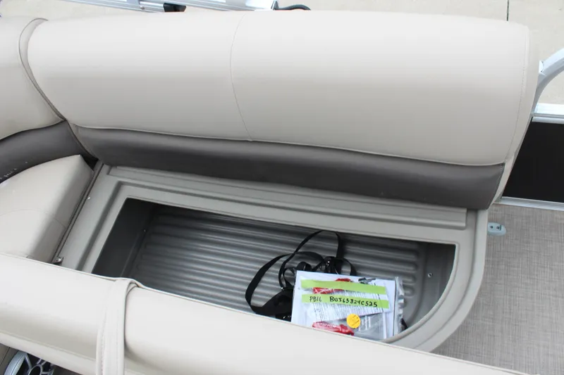 Slide: The Image of 2025 Sun Tracker Party Barge 16 DLX storage compartment with beige seating and accessories. - 13