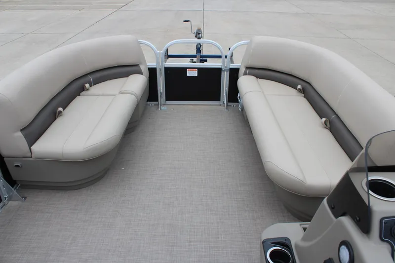 Slide: The Image of 2025 Sun Tracker Party Barge 16 DLX interior with beige seating and spacious layout. - 16