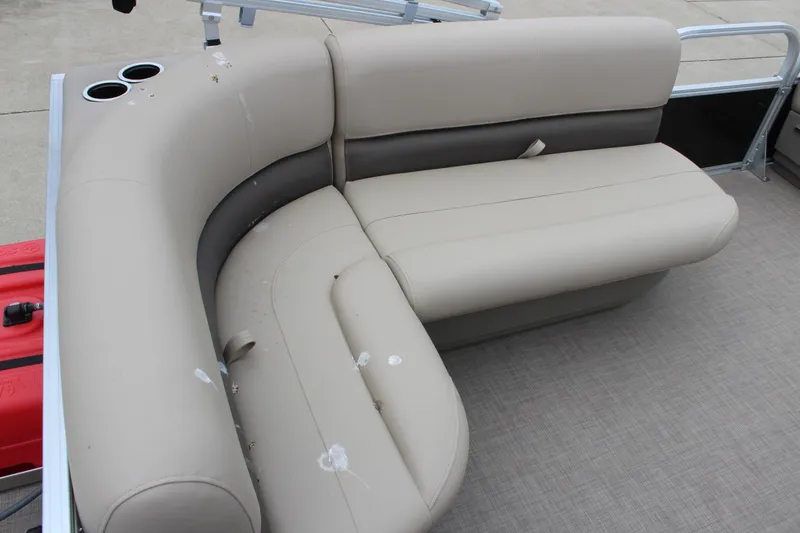 Slide: The Image of 2025 Sun Tracker Party Barge 16 DLX seating area with beige upholstery and cup holders. - 9