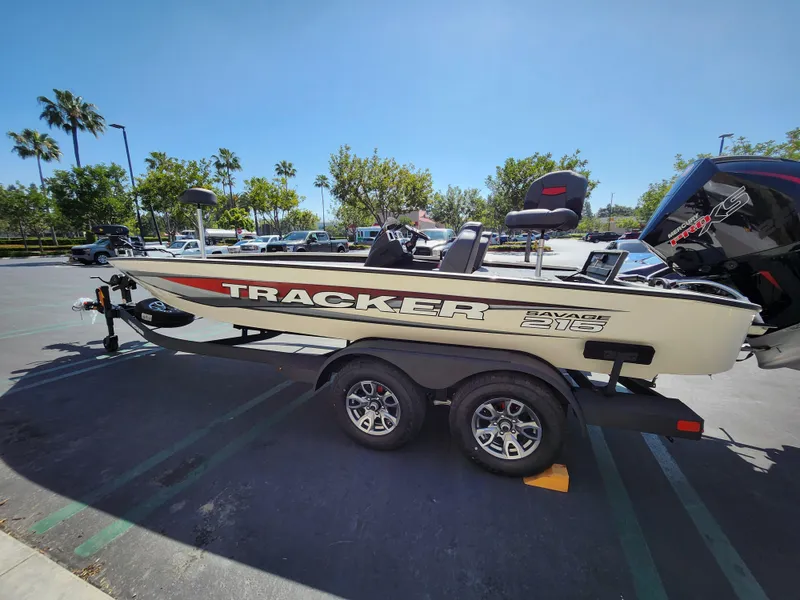 The Image of 2025 Tracker Savage 215 boat on trailer in sunny parking lot. - 0