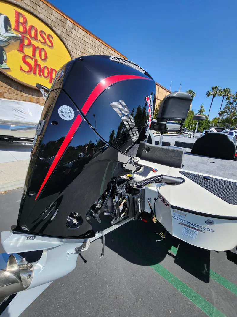 Slide: The Image of 2025 Tracker Savage 215 boat engine at Bass Pro Shops, sunny day. - 3