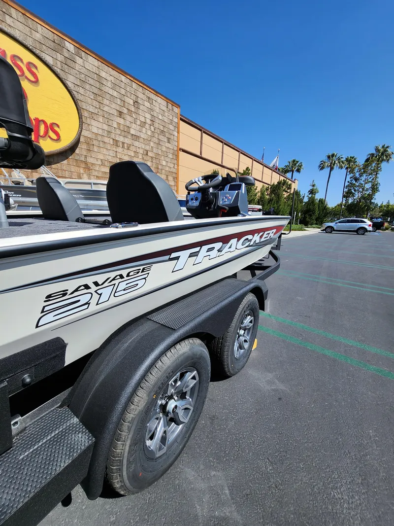 Slide: The Image of 2025 Tracker Savage 215 boat parked outdoors on a sunny day. - 4