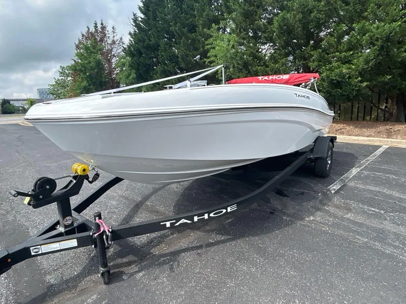 Slide: The Image of 2025 Tahoe T18 boat on trailer in parking lot, surrounded by trees. - 0