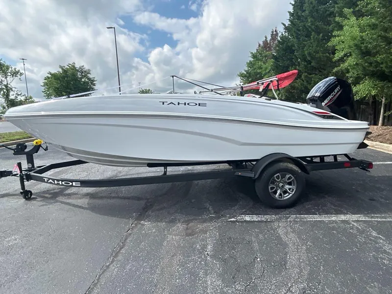 Slide: The Image of 2025 Tahoe T18 boat on trailer, parked outdoors under cloudy sky. - 1