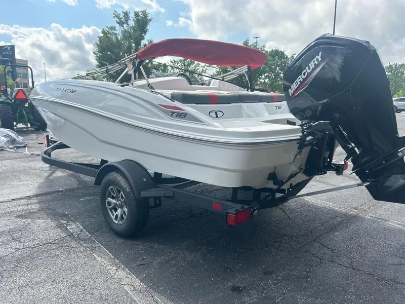 Slide: The Image of 2025 Tahoe T18 boat with Mercury engine on trailer, parked outdoors. - 2