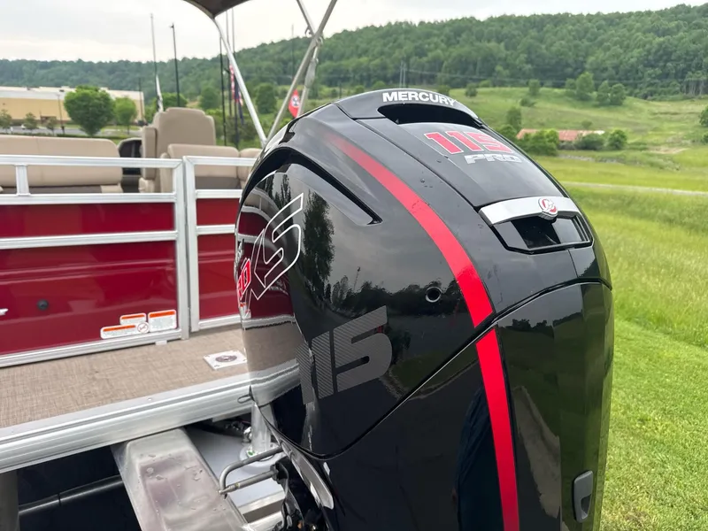 Slide: The Image of 2025 Sun Tracker Party Barge 22 RF DLX with Mercury outboard motor, scenic background. - 2