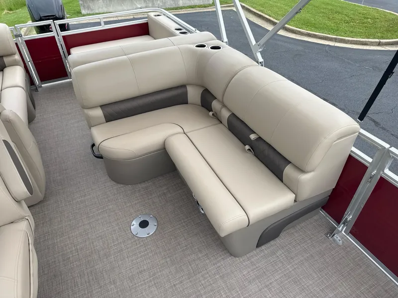 Slide: The Image of 2025 Sun Tracker Party Barge 22 RF DLX interior with beige seating and red accents. - 6