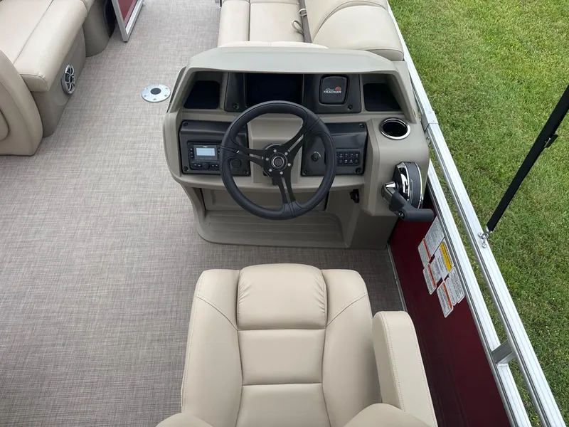 Slide: The Image of 2025 Sun Tracker Party Barge 22 RF DLX helm with beige seating and modern controls. - 8