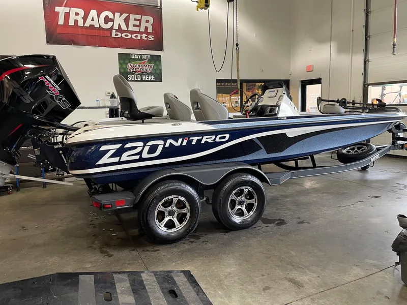 Slide: The Image of 2024 Nitro Z20 boat in showroom, featuring sleek design and dual-axle trailer. - 1