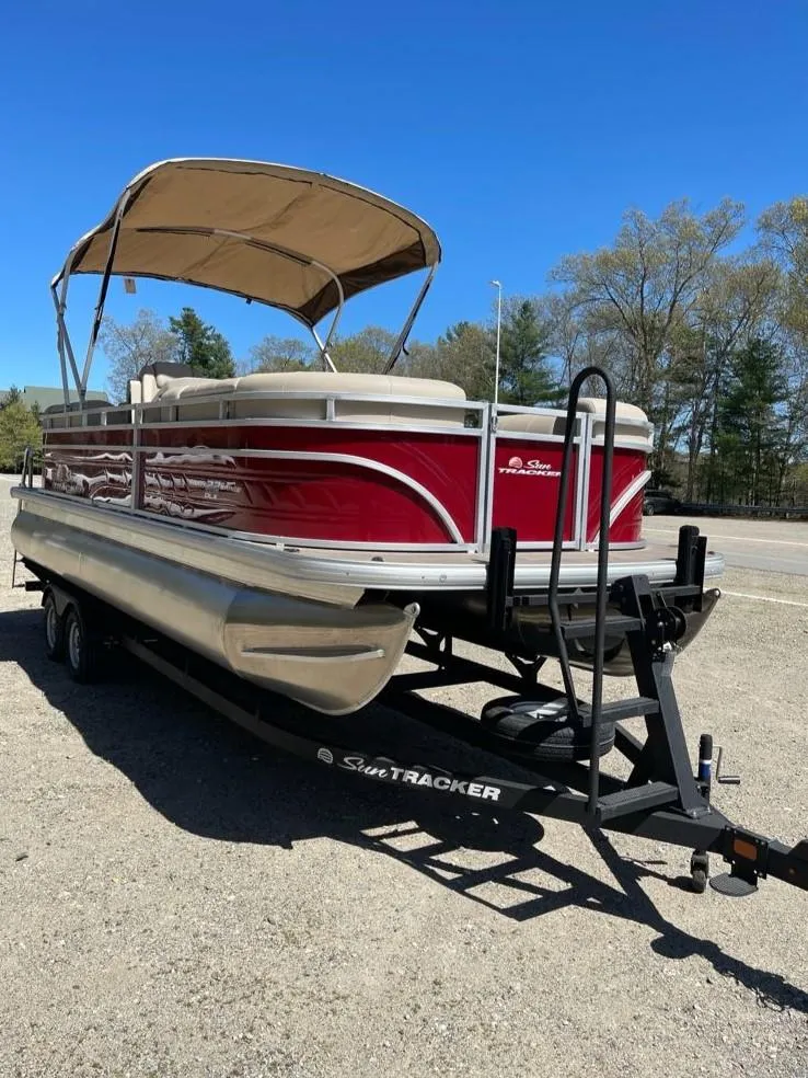 Slide: The Image of 2025 Sun Tracker Party Barge 22 RF DLX pontoon boat on trailer, red with canopy. - 2