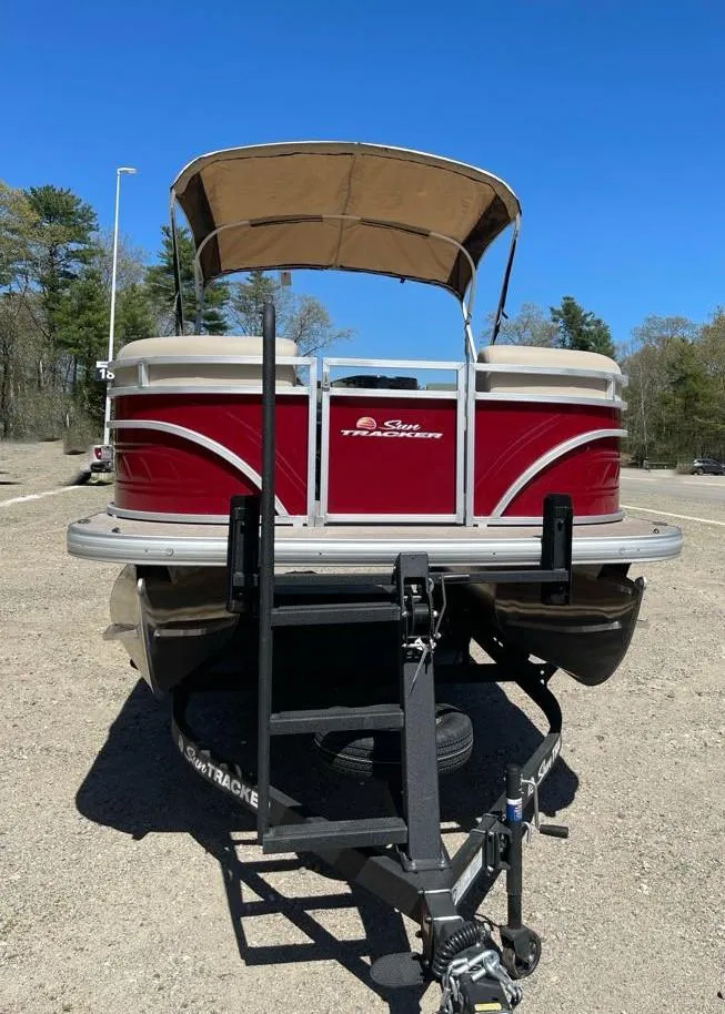 Slide: The Image of 2025 Sun Tracker Party Barge 22 RF DLX pontoon boat on trailer, parked outdoors. - 3