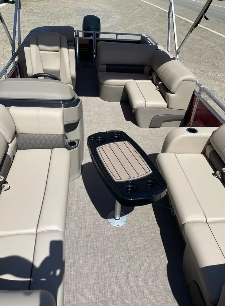 Slide: The Image of 2025 Sun Tracker Party Barge 22 RF DLX interior with beige seating and central table. - 8