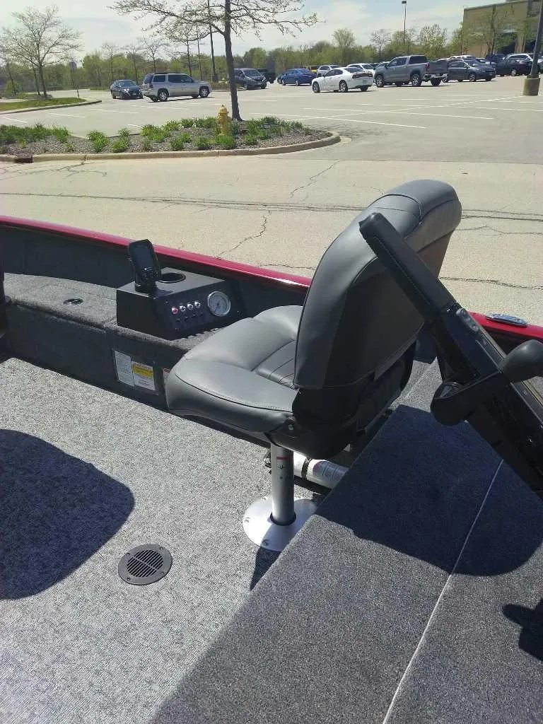 Slide: The Image of 2025 Tracker Super Guide V-16 T boat interior with seating in a parking lot. - 2