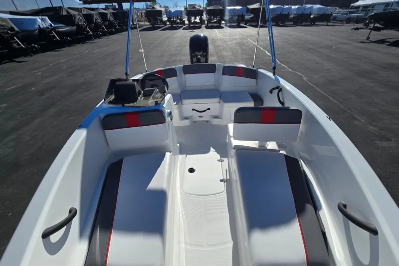 Slide: The Image of 2025 Tahoe T16 boat interior with seating and steering console, parked outdoors. - 13