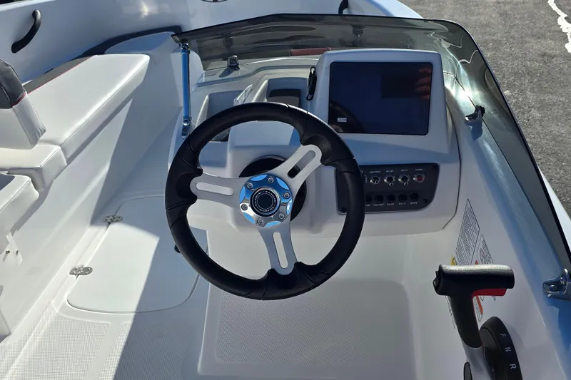 Slide: The Image of 2025 Tahoe T16 boat cockpit with steering wheel, control panel, and seating. - 16