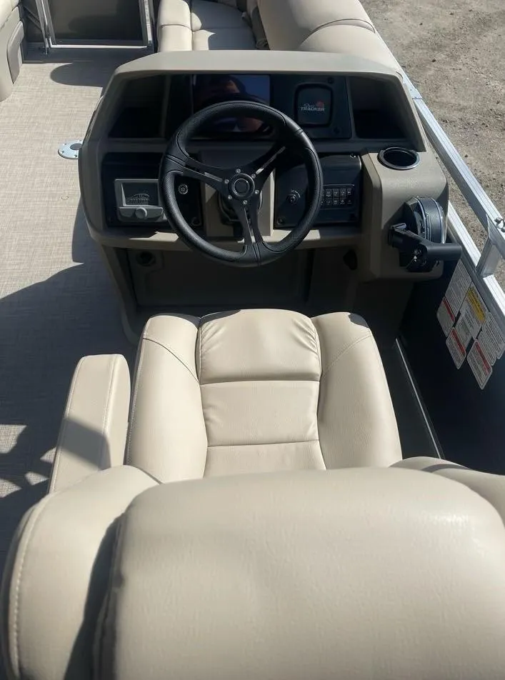 Slide: The Image of 2025 Sun Tracker Party Barge 22 DLX interior with beige captain's chair and steering console. - 7