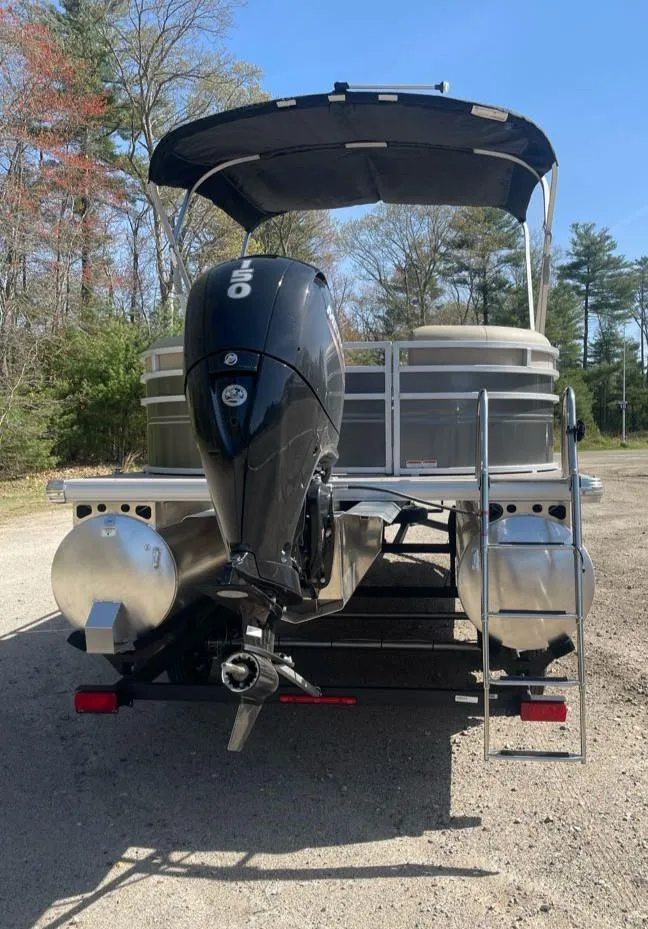 Slide: The Image of 2025 Sun Tracker Party Barge 22 DLX pontoon boat with outboard motor, parked outdoors. - 8