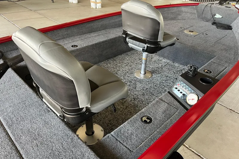 Slide: The Image of 2025 Tracker Super Guide V-16 T boat interior with gray seats and red trim. - 5