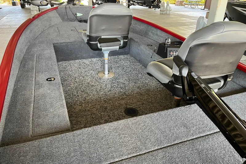 Slide: The Image of 2025 Tracker Super Guide V-16 T boat interior with gray seating and carpeted flooring. - 7