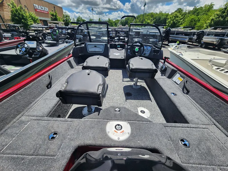 Slide: The Image of 2025 Tracker Pro Guide V-16 WT boat interior with seating and dashboard, displayed outdoors. - 3