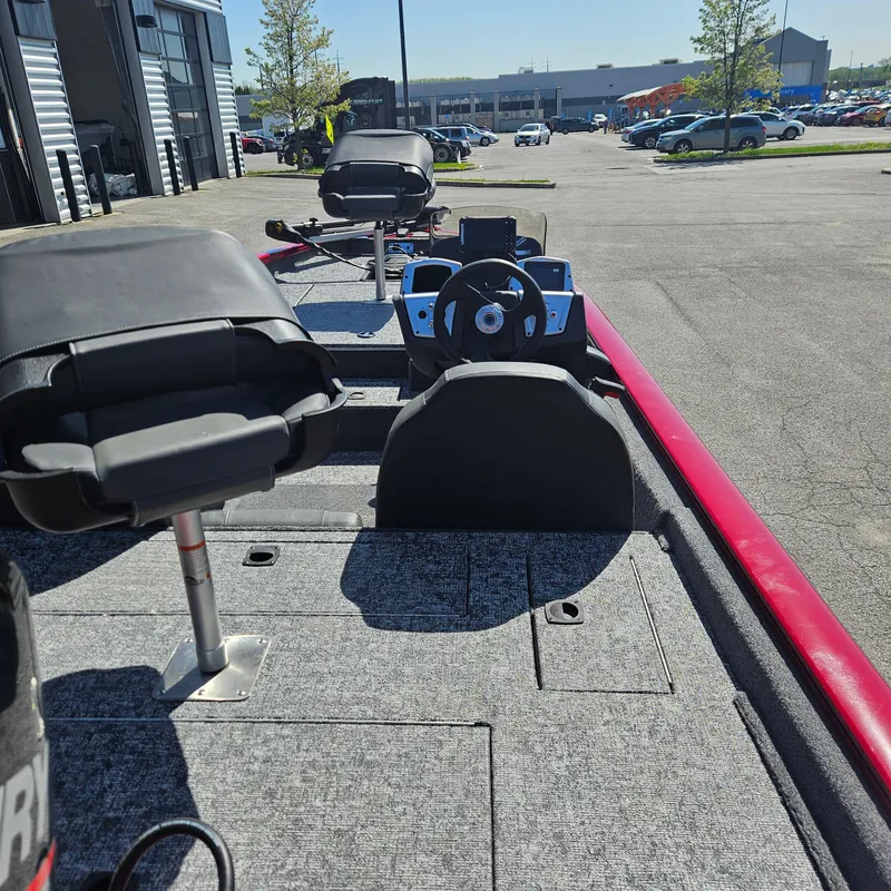 Slide: The Image of 2025 Tracker Pro Team 175 boat interior with steering wheel and seats in a parking lot. - 4