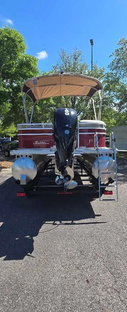Slide: The Image of 2025 Sun Tracker Party Barge 22 RF DLX pontoon boat with canopy, parked outdoors. - 4