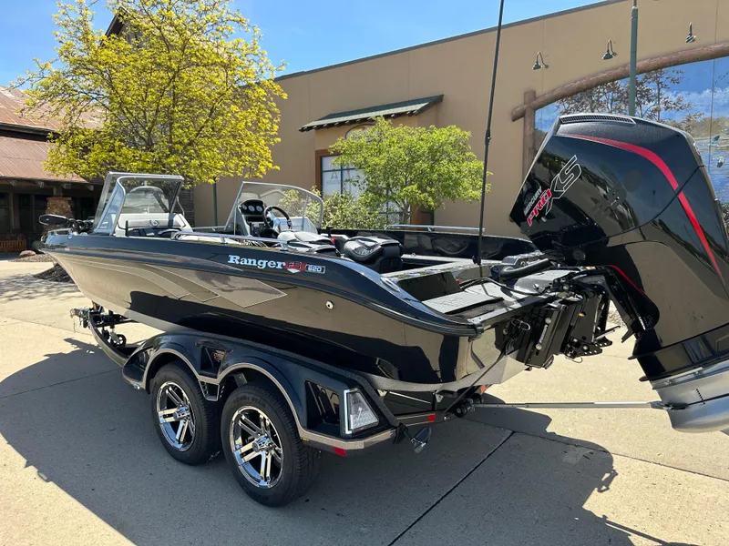 Slide: The Image of 2025 Ranger 620FS Cup Equipped boat with sleek design and powerful engine, parked outdoors. - 2