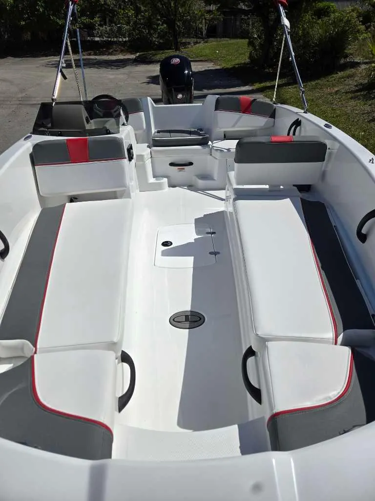 Slide: The Image of 2025 Tahoe T18 boat interior with white and gray seating, red accents, and spacious layout. - 7
