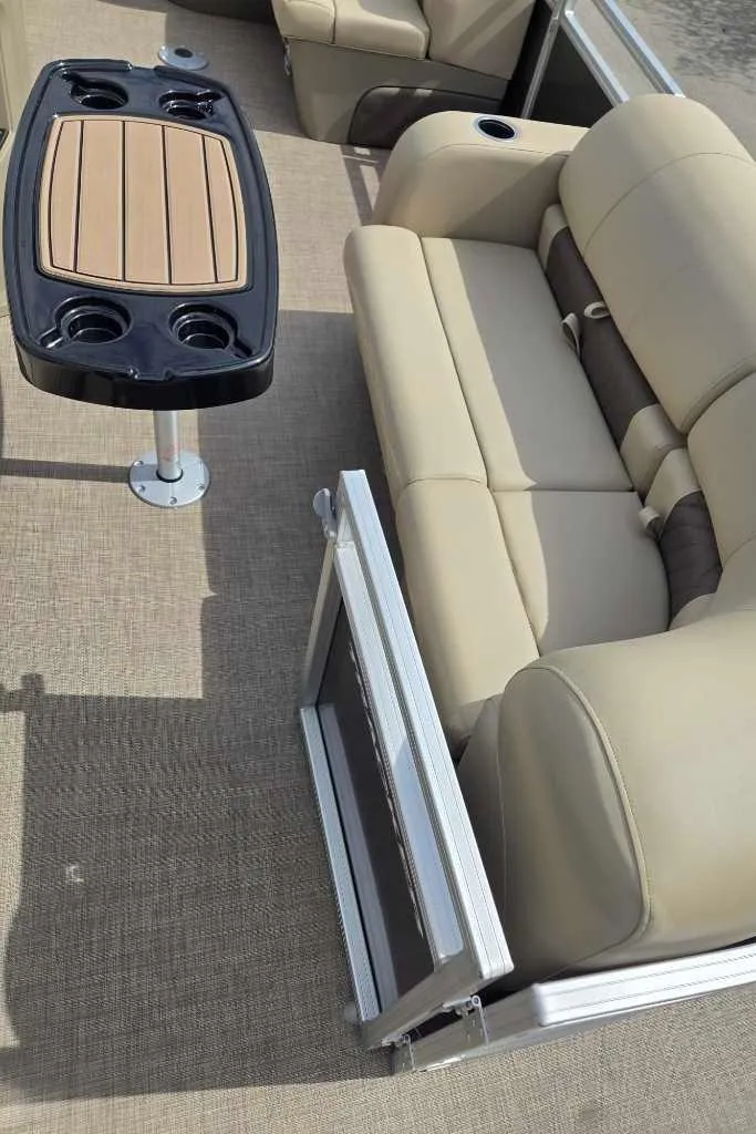 Slide: The Image of 2025 Sun Tracker Party Barge 22 RF DLX interior with beige seating and table. - 3