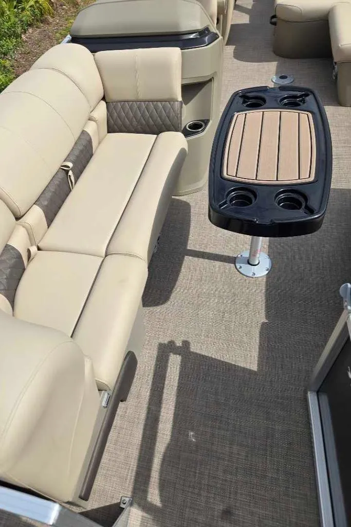 Slide: The Image of 2025 Sun Tracker Party Barge 22 RF DLX interior with beige seating and a central table. - 5