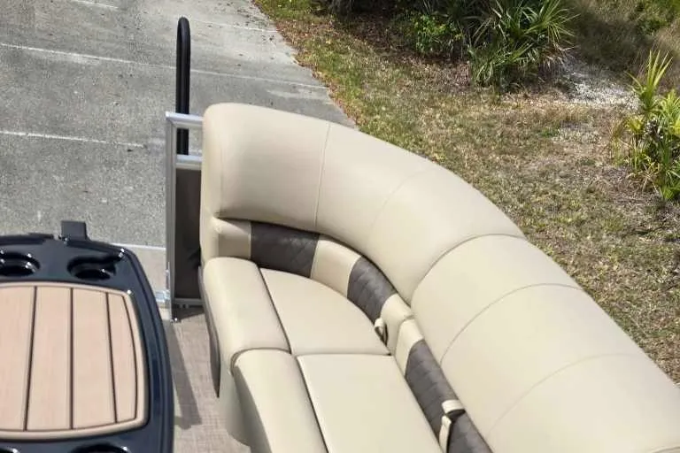 Slide: The Image of 2025 Sun Tracker Party Barge 22 RF DLX with beige seating and cup holders. - 6