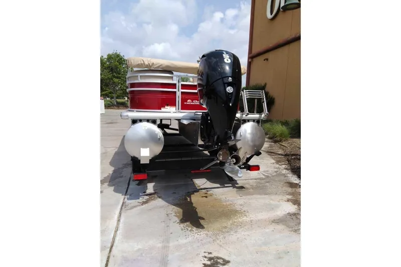 Slide: The Image of 2025 Sun Tracker Party Barge 22 DLX pontoon boat with outboard motor, parked outdoors. - 71