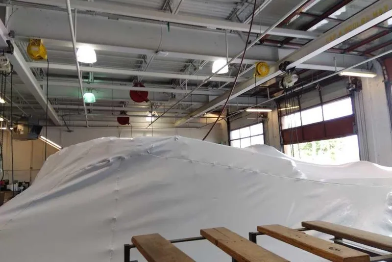 Slide: The Image of Covered 2025 Sun Tracker Party Barge 22 DLX in a spacious indoor storage facility. - 74