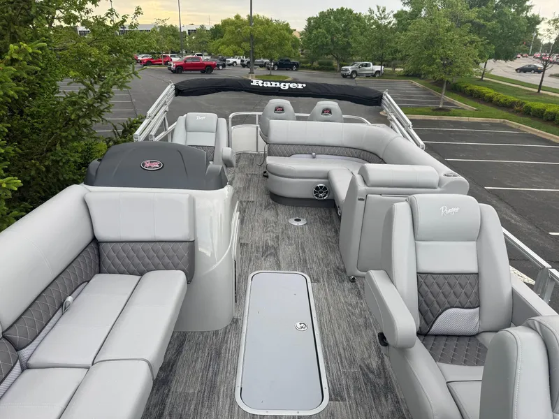 Slide: The Image of 2025 Ranger Reata 223FC pontoon boat with luxurious seating and modern design in a parking lot. - 3