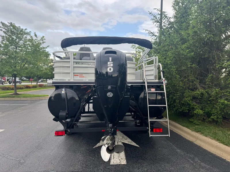 Slide: The Image of 2025 Ranger Reata 223FC boat with 150 HP motor, parked on asphalt. - 4