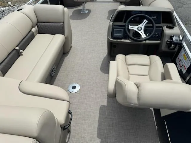 Slide: The Image of 2025 Sun Tracker Fishin' Barge 22 DLX interior with beige seating and steering console. - 10