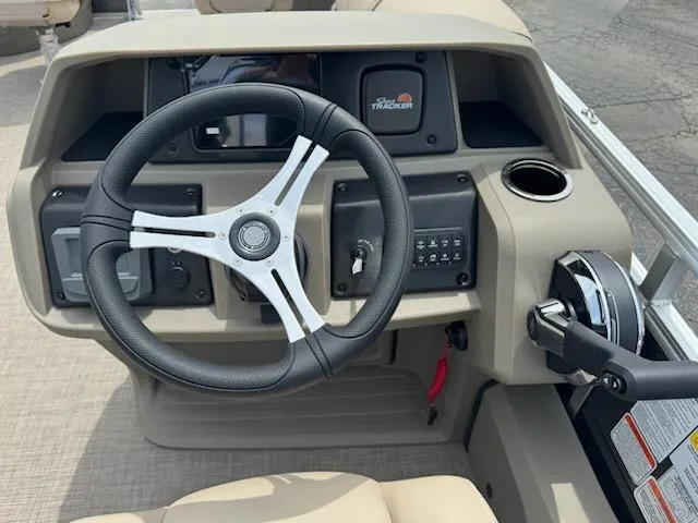 Slide: The Image of 2025 Sun Tracker Fishin' Barge 22 DLX dashboard with steering wheel and controls. - 11