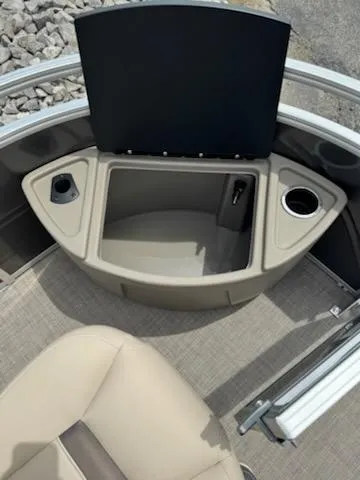 Slide: The Image of 2025 Sun Tracker Fishin' Barge 22 DLX interior with storage compartment and cup holders. - 6