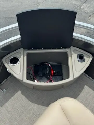 Slide: The Image of 2025 Sun Tracker Fishin' Barge 22 DLX storage compartment with cup holders and wiring. - 7