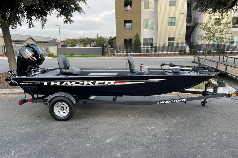 The Image of 2025 Tracker Panfish 17 boat on trailer, parked outdoors near buildings. - 0