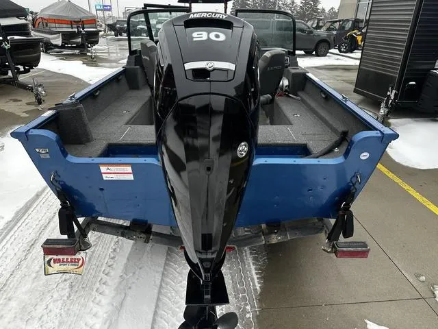 Slide: The Image of 2022 Lund 1650 Rebel XL Sport boat with Mercury 90 engine, parked on snowy pavement. - 4