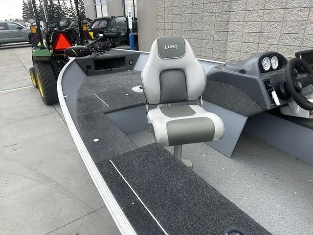 Slide: The Image of 2005 Lund 16 REBEL boat with seating and dashboard, parked outdoors. - 10