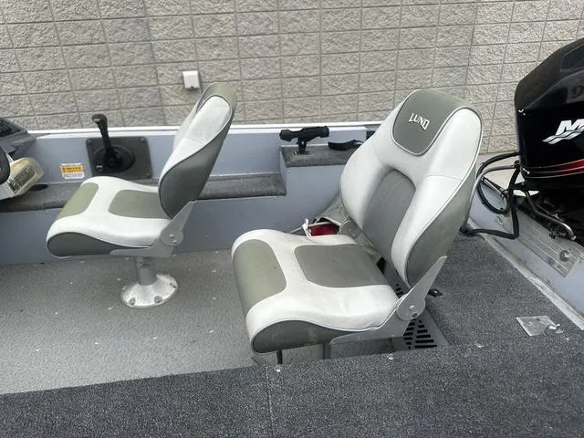 Slide: The Image of 2005 Lund 16 REBEL boat interior with two cushioned seats and a motor. - 9